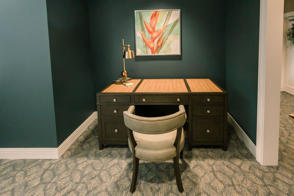A cozy home office setup with a desk, chair, and decorative artwork.