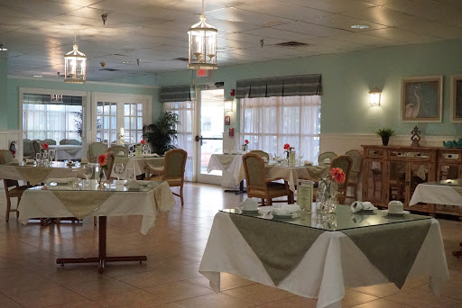 A spacious and elegantly designed dining area, featuring well-set tables and comfortable seating.