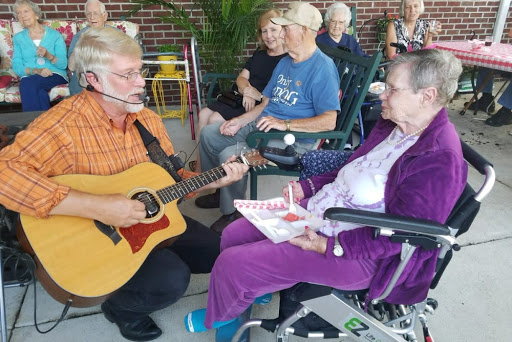 A musician performing for elderly residents in a care home, creating a lively and engaging atmosphere.