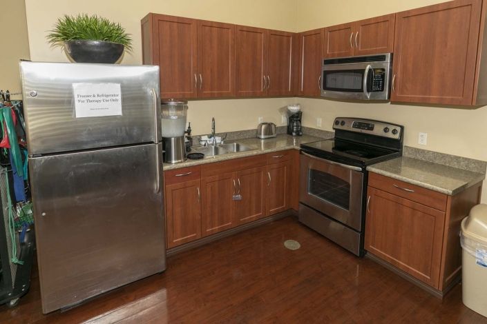 A modern kitchen featuring stainless steel appliances and wooden cabinets.