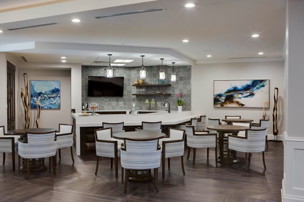 A modern lounge area featuring a bar counter, elegant seating, and stylish pendant lighting.