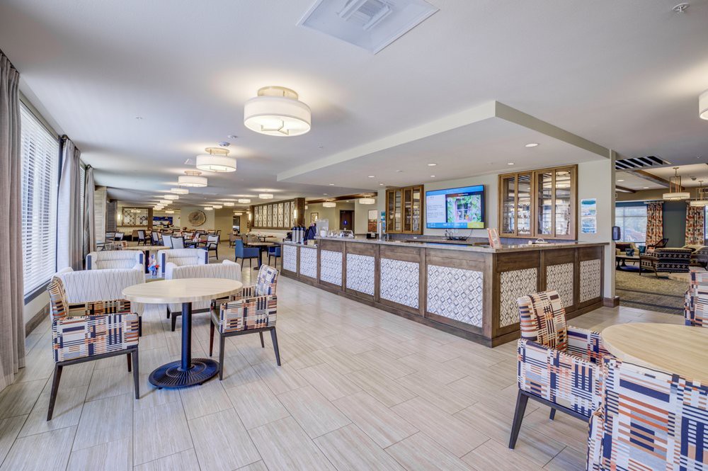A modern dining area with tables and chairs, featuring stylish lighting and a spacious layout.
