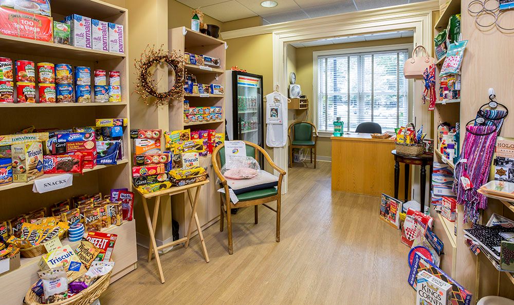 A small shop with snacks displayed on shelves and a seating area.