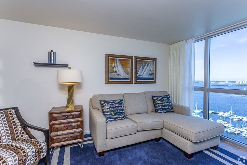 A cozy living room with a sectional sofa, nautical-themed decor, and ample natural light.