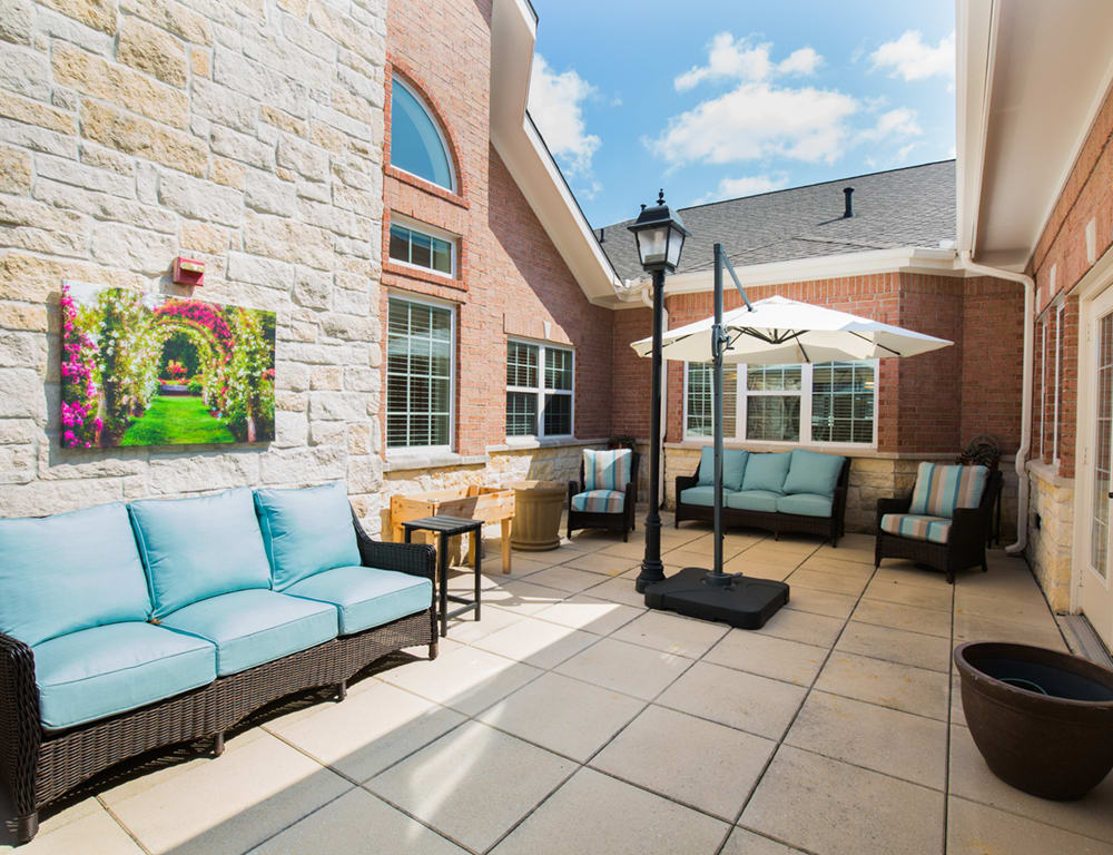 A spacious patio with comfortable outdoor seating and umbrellas on a sunny day.