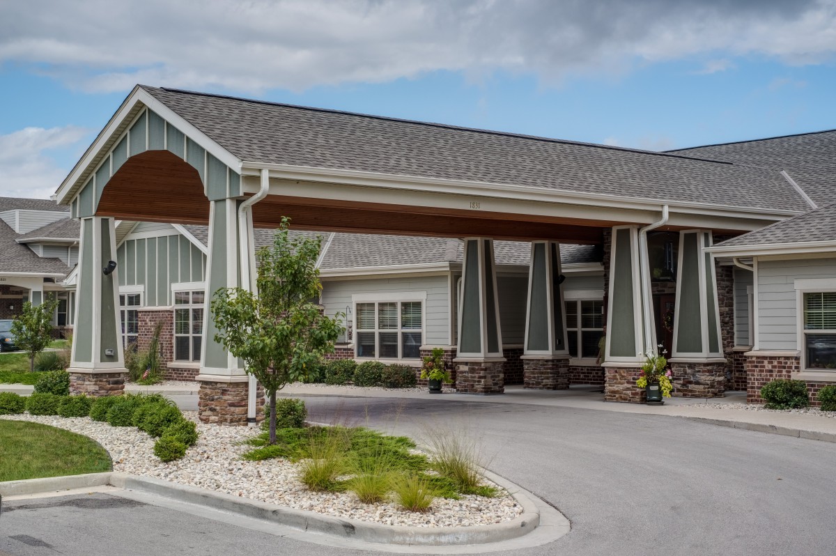 A well-designed building with a covered entrance and landscaped surroundings.