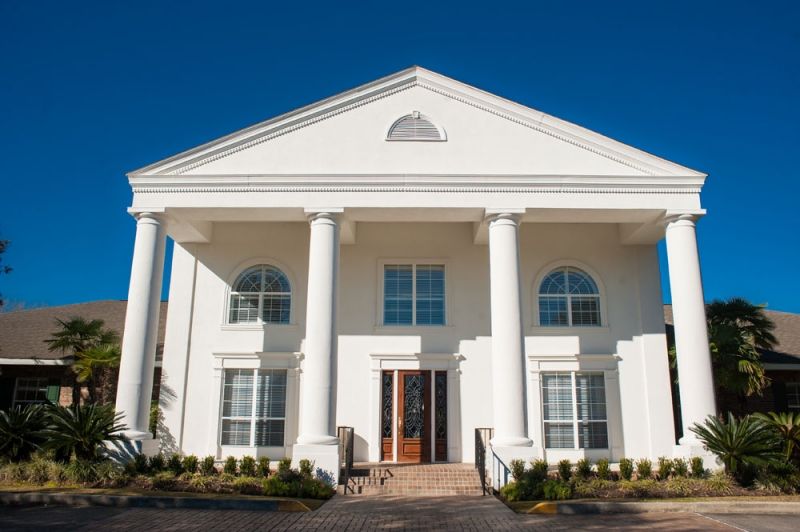 A grand house with a classic white facade and prominent columns.