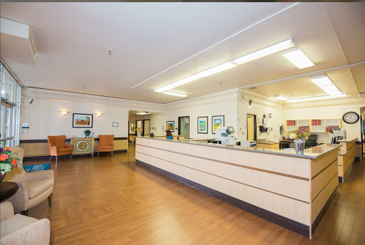 A welcoming reception area in a healthcare facility, featuring comfortable seating and informative wall art.