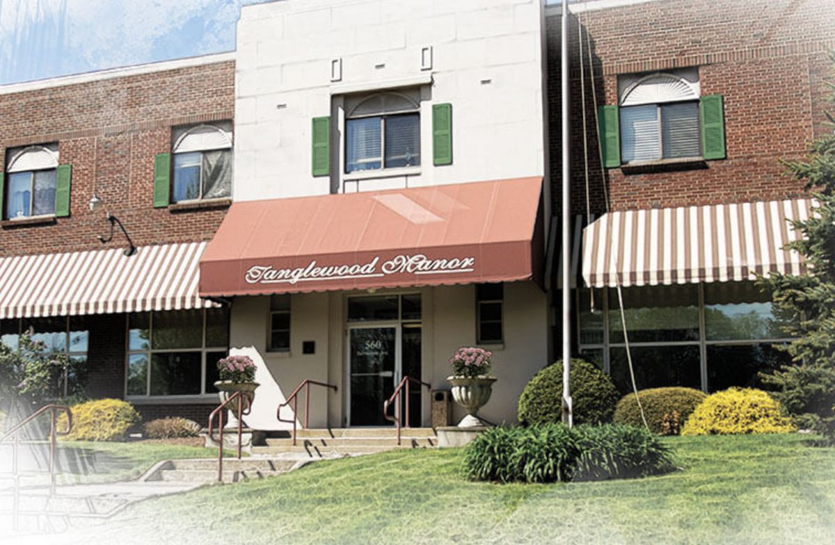 The exterior of a building with an awning displaying its name, featuring steps leading to the entrance.