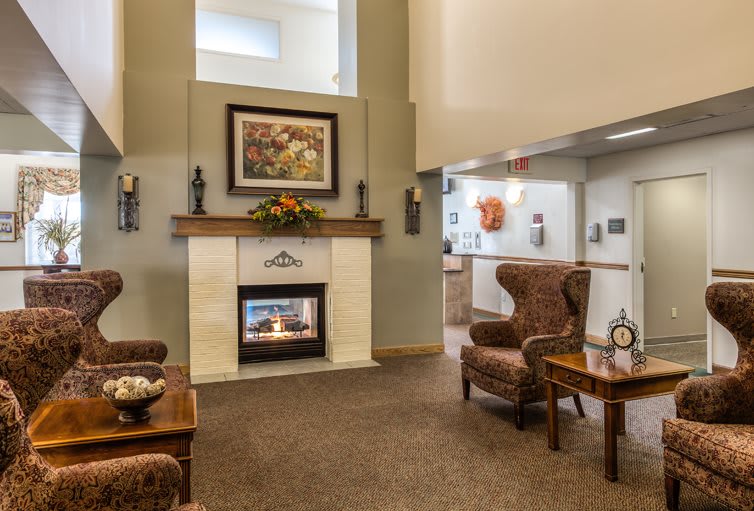 A cozy living room featuring a central fireplace, comfortable armchairs, and elegant decor.