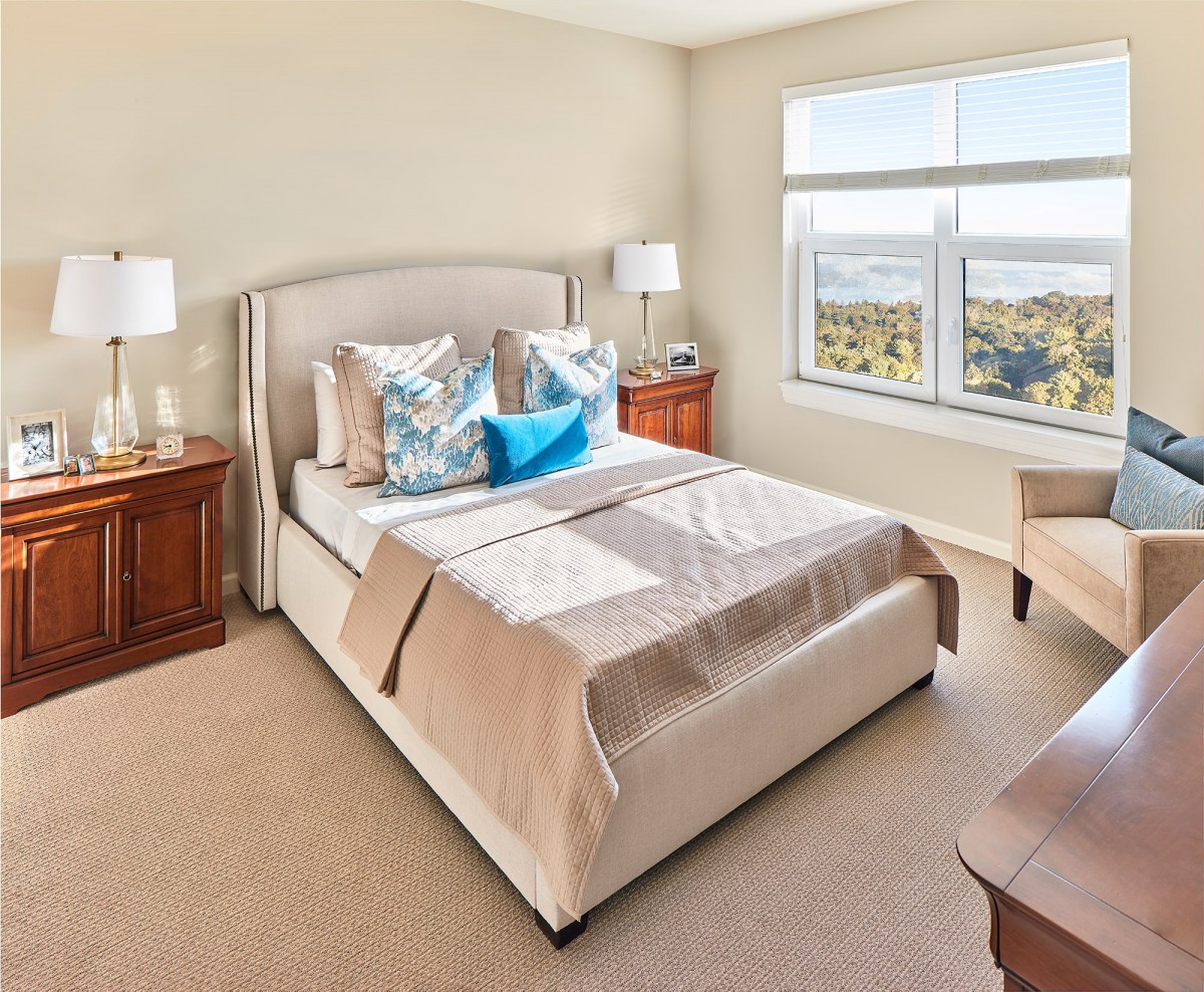 A well-lit bedroom with elegant decor and a scenic view from the window.