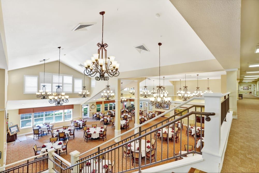 Spacious dining hall with elegant chandeliers and multiple tables.
