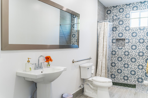A modern bathroom featuring a stylish sink, clean toilet, and decorative wall tiles.