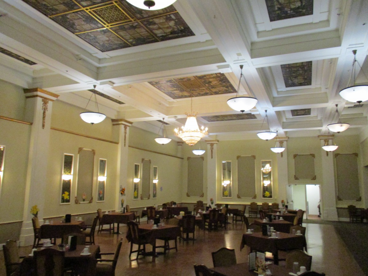 An elegant dining hall with ornate ceilings and chandeliers.
