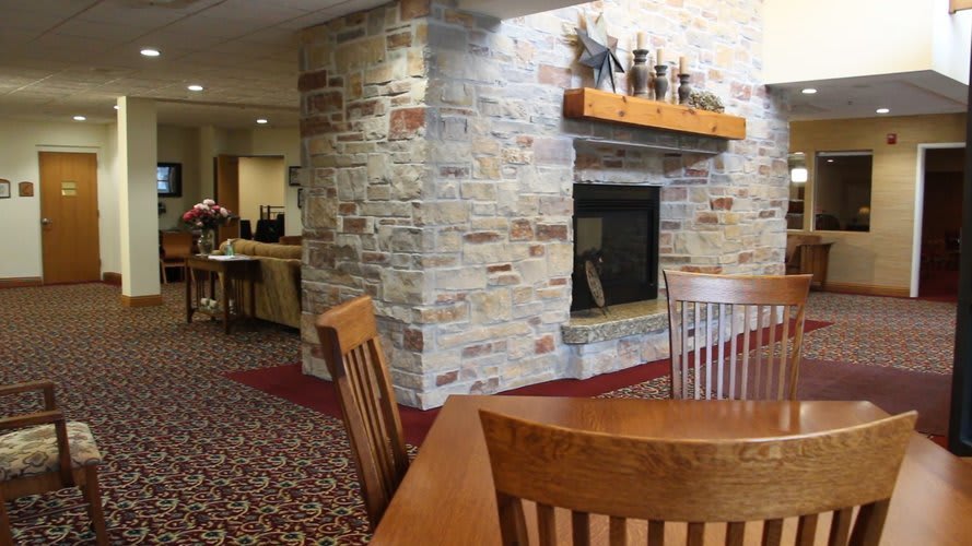 A cozy room featuring a stone fireplace and wooden furniture.