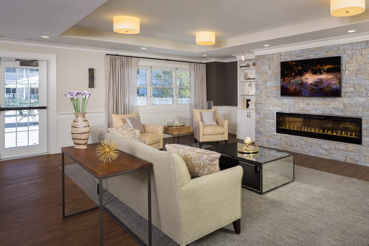A modern and cozy living room featuring neutral-toned furniture, a fireplace, and stylish decor.