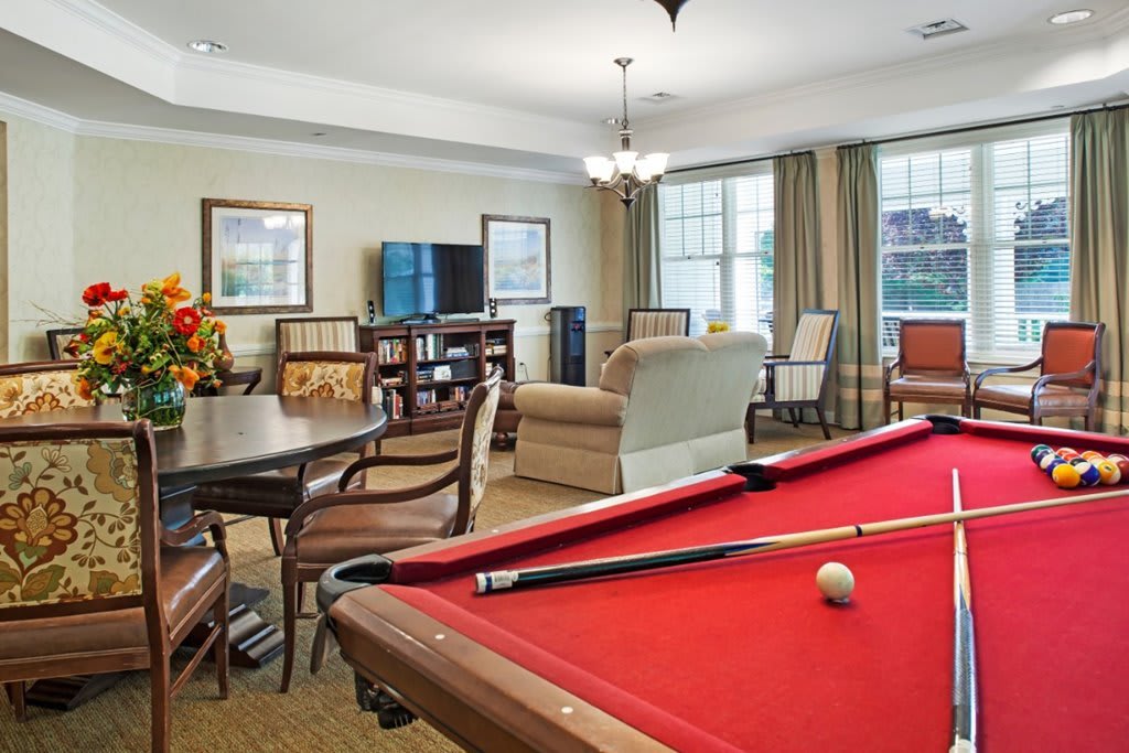 A cozy living room featuring a pool table and comfortable seating.