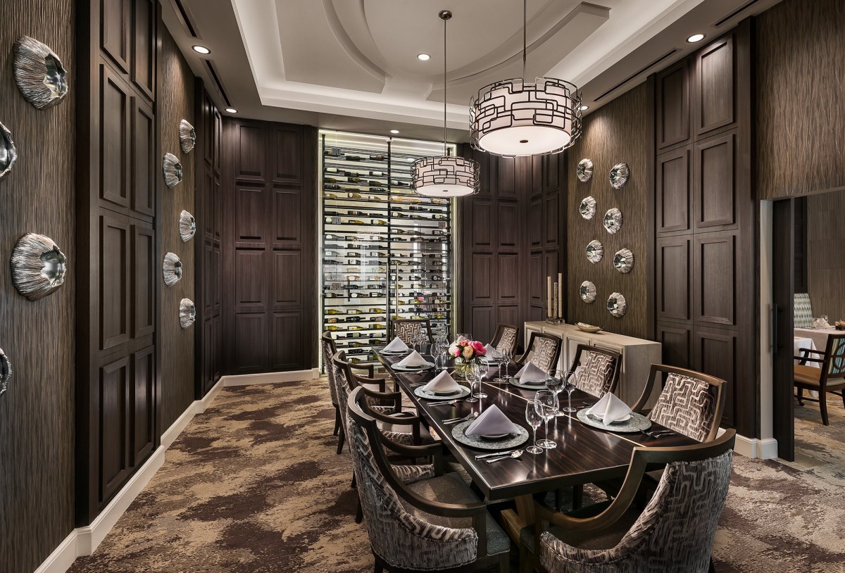 A luxurious dining room with elegant table settings and a modern wine storage display.