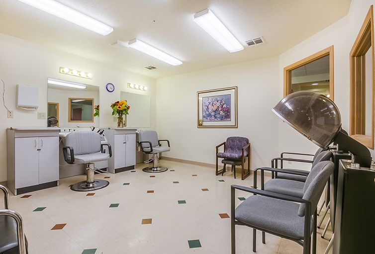 A well-lit salon interior with chairs, hair dryers, and a waiting area.