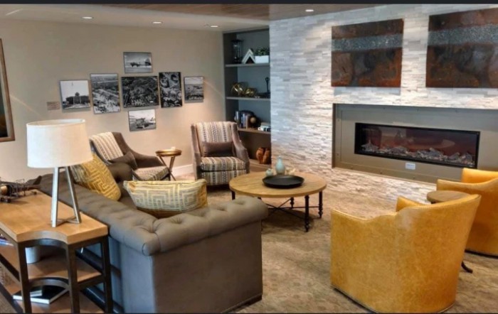 A cozy living room with modern decor, featuring a fireplace and comfortable seating.