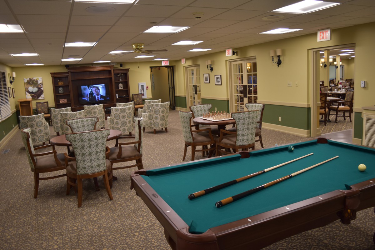 A cozy game room with a pool table and comfortable seating.