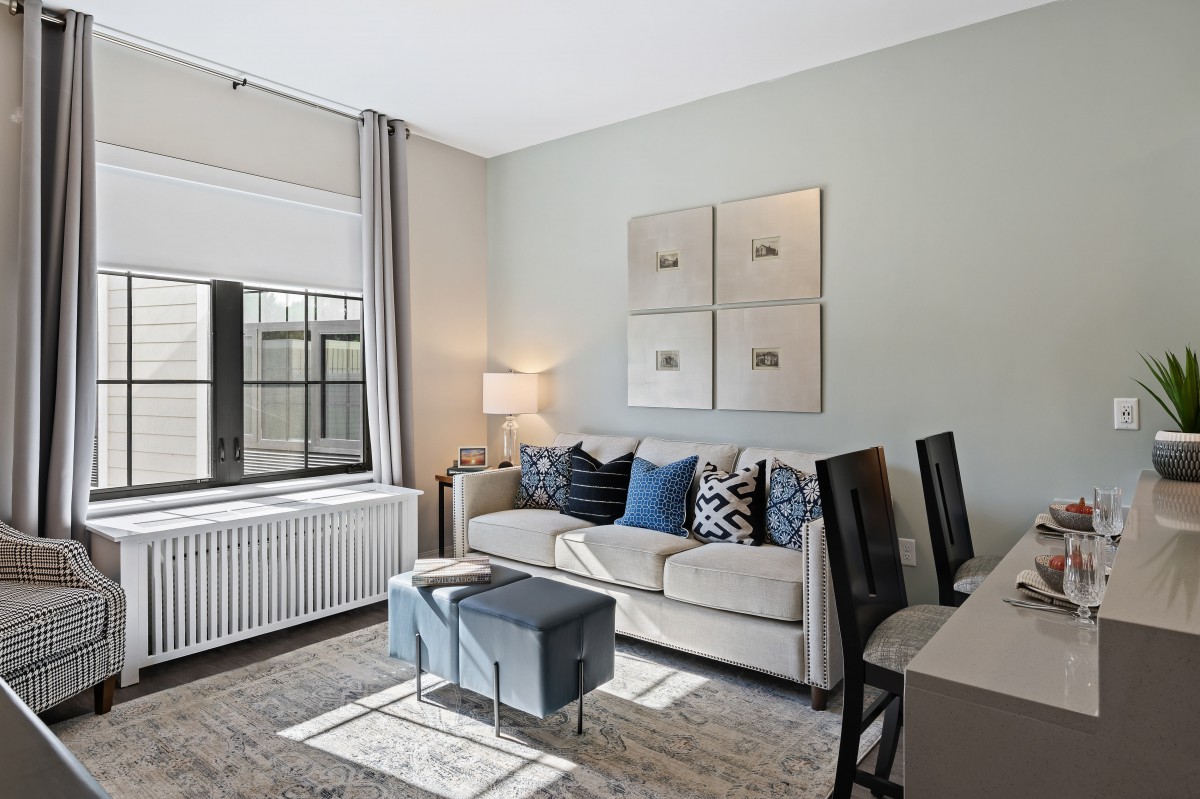 A modern living room with a comfortable sofa, stylish decor, and ample natural light.