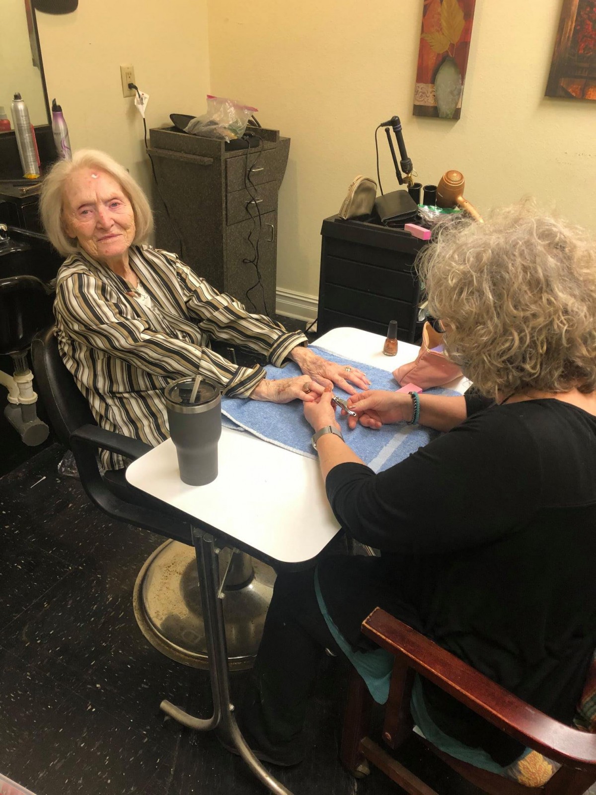 A woman receives a manicure at a nail salon.
