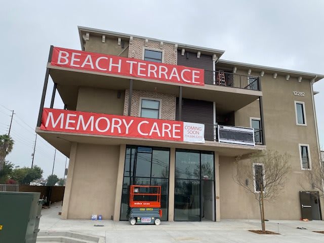 A multi-story building with signs for Beach Terrace Memory Care, indicating a healthcare facility or retirement home.