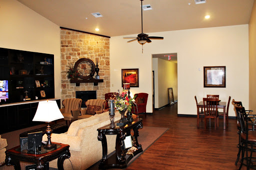 A cozy living room featuring elegant furniture and a stone accent wall.