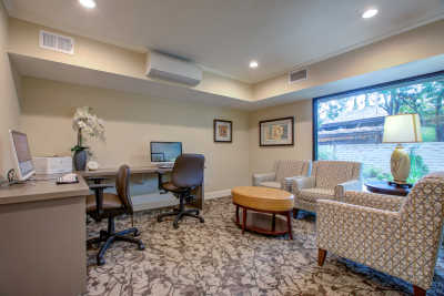 A modern office space with a computer workstation and a comfortable seating area.