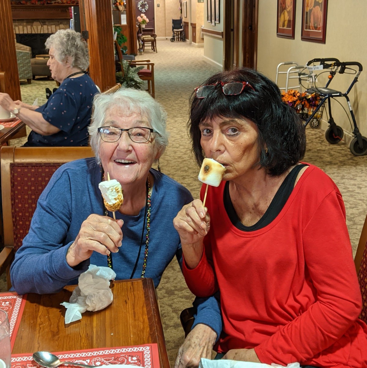 Two women enjoying ice cream together indoors.