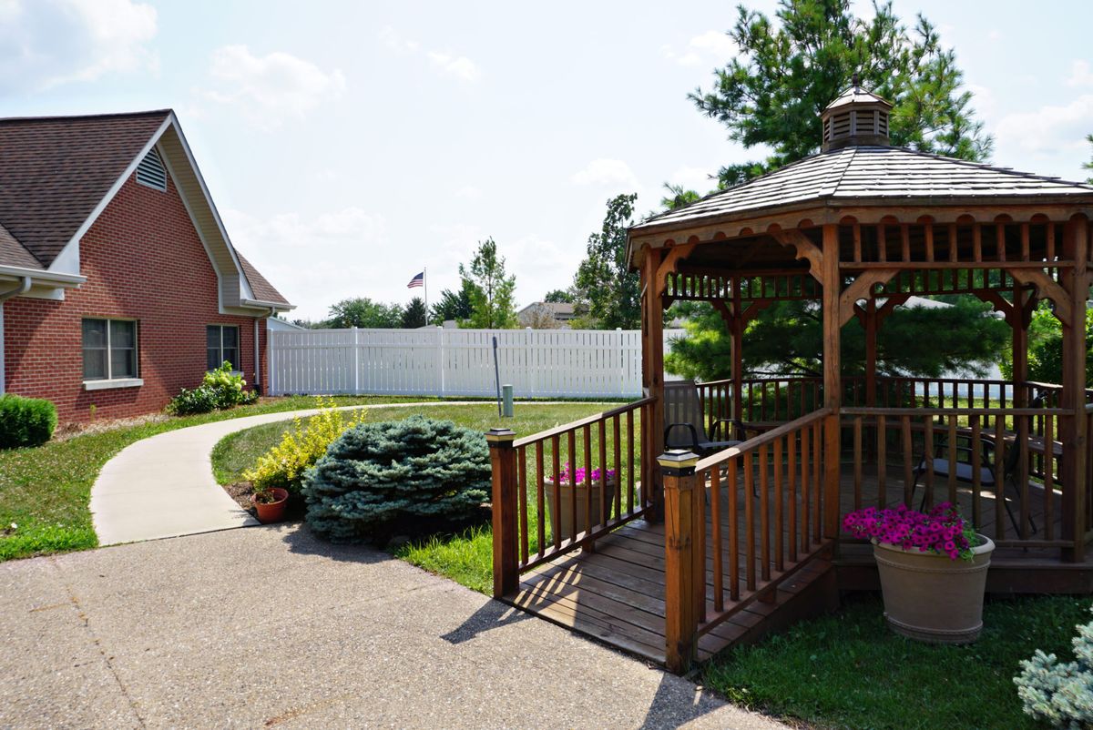 A well-maintained backyard featuring a wooden gazebo with surrounding landscaping.