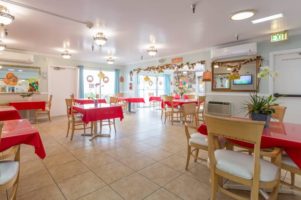 An indoor dining area with tables and chairs, decorated for the holiday season.