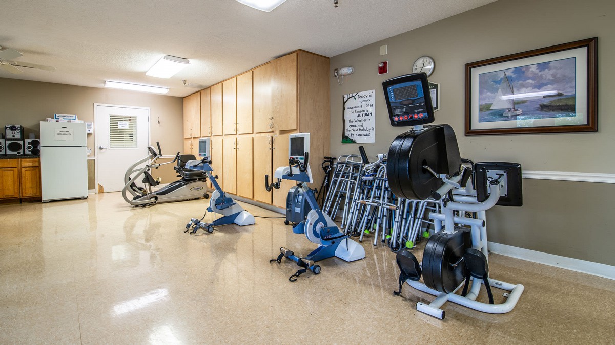 A well-equipped gym with various exercise machines and stationary bikes arranged neatly.