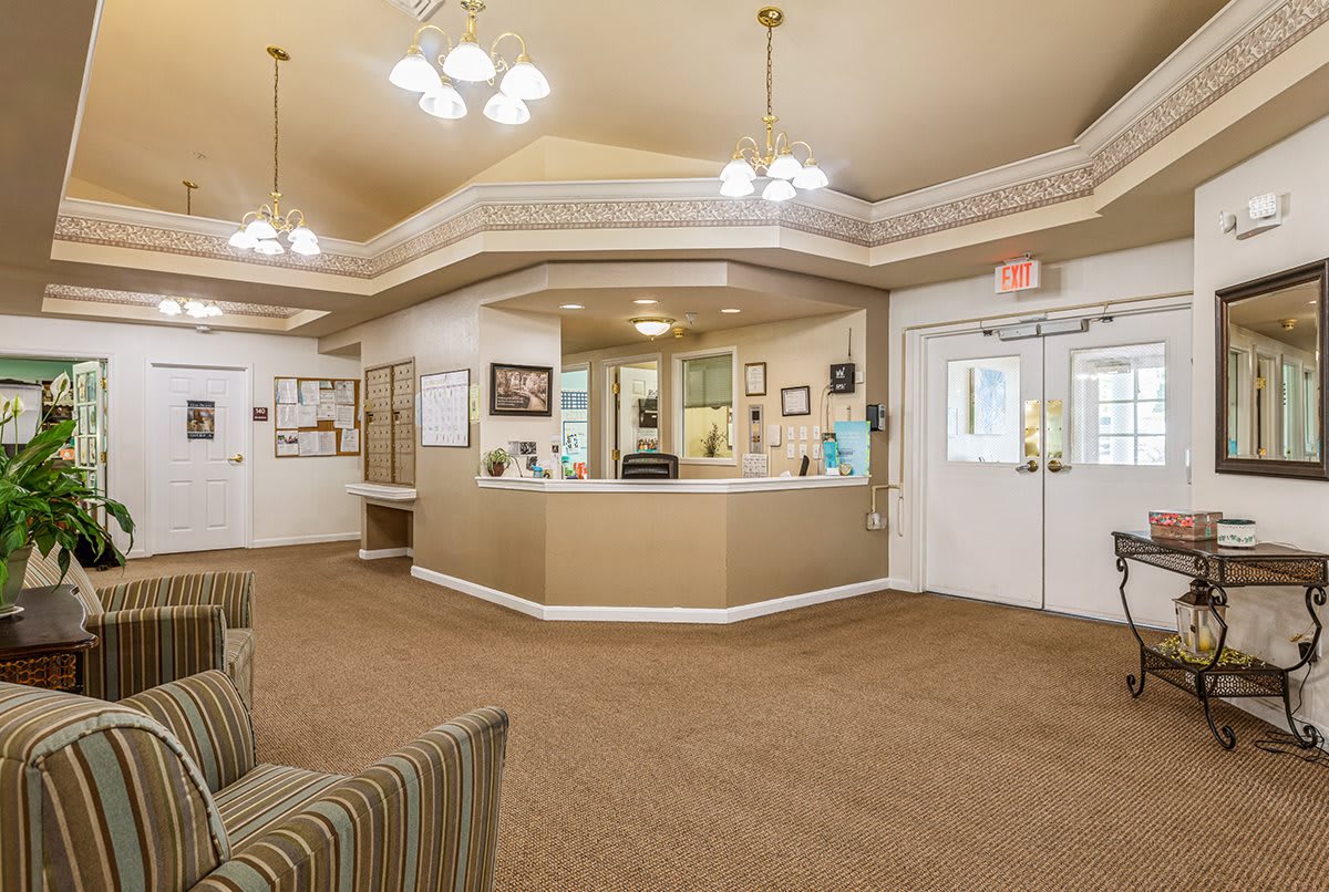 A well-lit reception area with a central counter and comfortable seating.