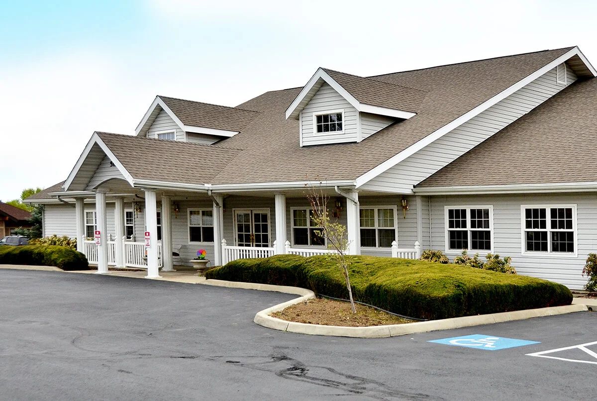 A well-maintained residential building with a sloped roof and a surrounding driveway.