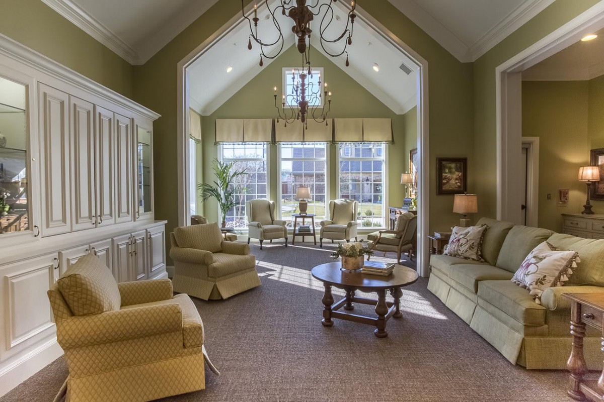 A spacious living room with elegant furniture and large windows allowing natural light to flood the space.