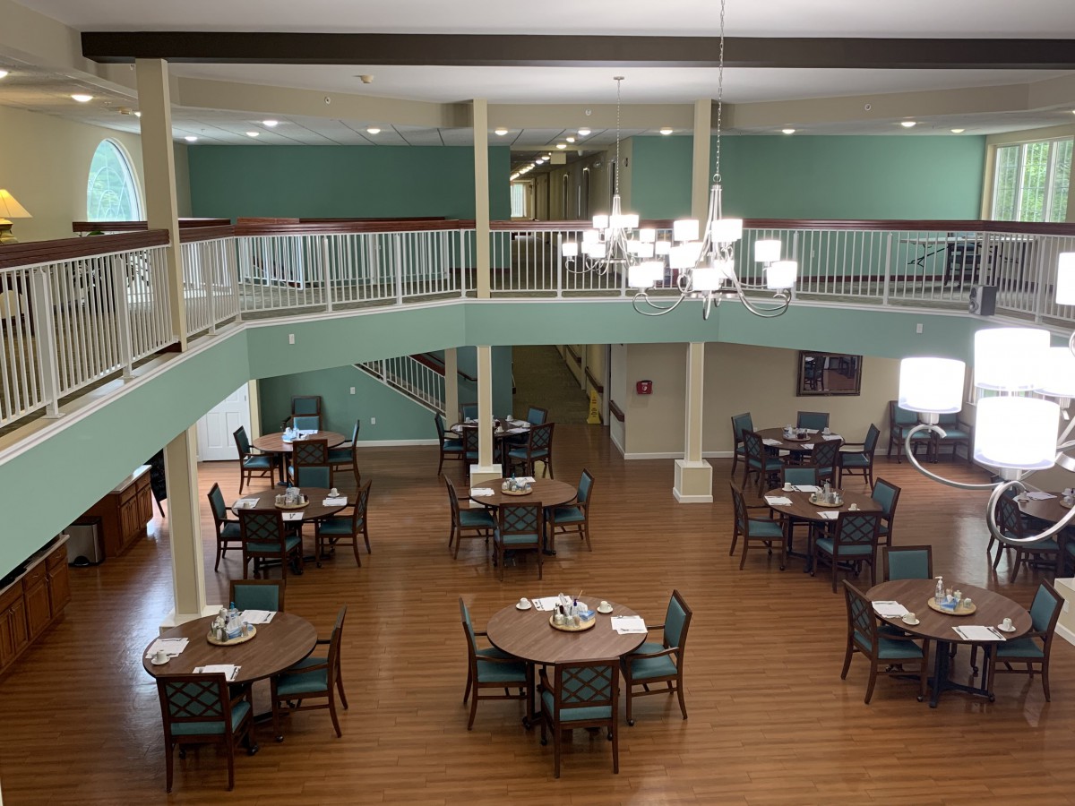 Spacious dining area with multiple tables and a balcony overlooking the room.