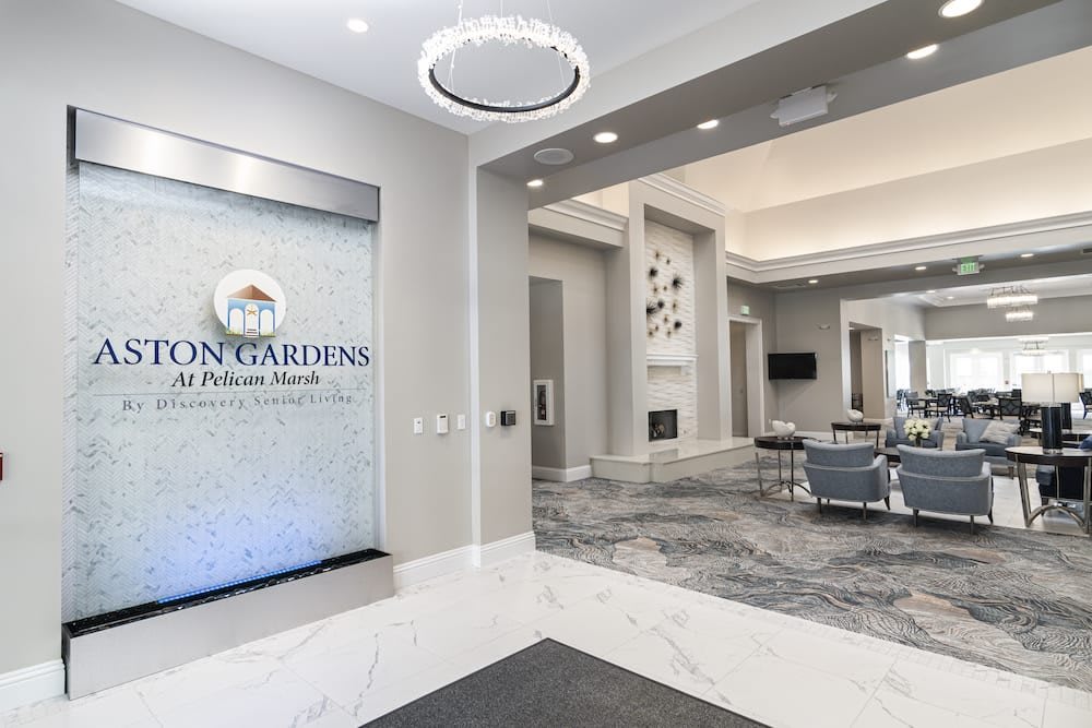A modern and elegant lobby with a seating area and chandelier.