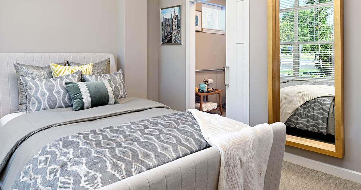 A modern bedroom with stylish bedding and contemporary decor.