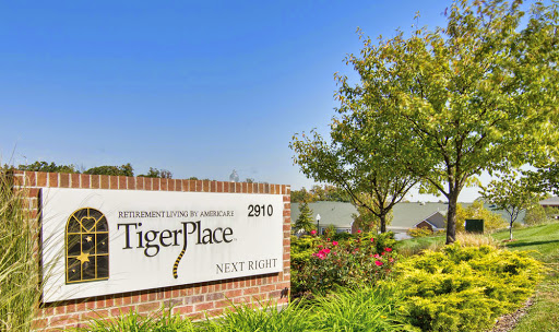Entrance sign of TigerPlace showcasing a sunny day with landscaped greenery.