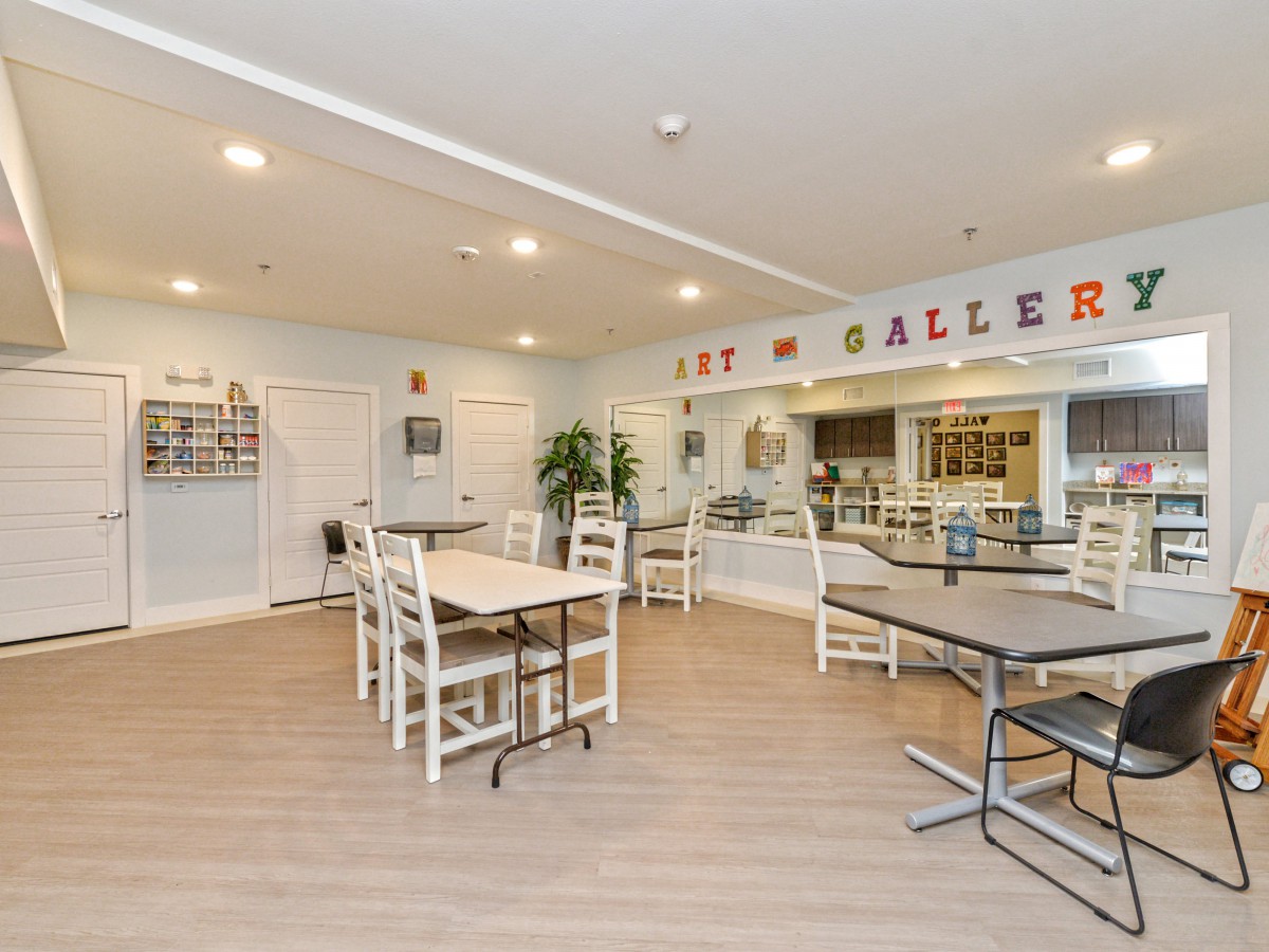 A modern art gallery interior with tables and chairs.