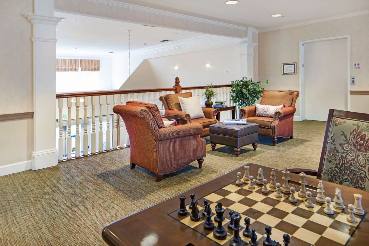 A cozy lounge area with comfortable chairs, a coffee table, and a chessboard.