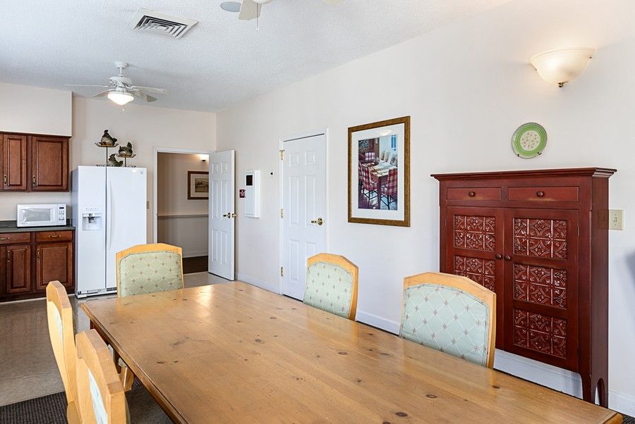 A dining room with a wooden table, chairs, and wall artwork.