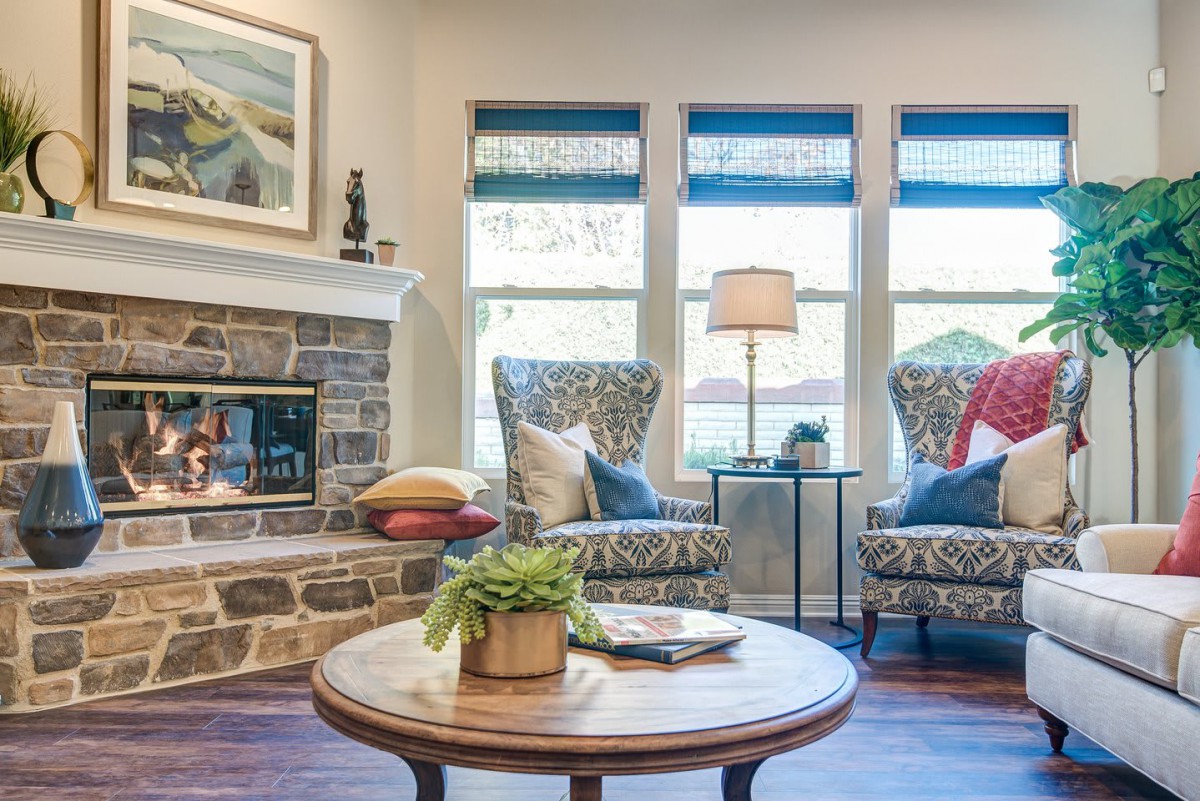 A cozy living room with elegant seating, a stone fireplace, and decorative accents.