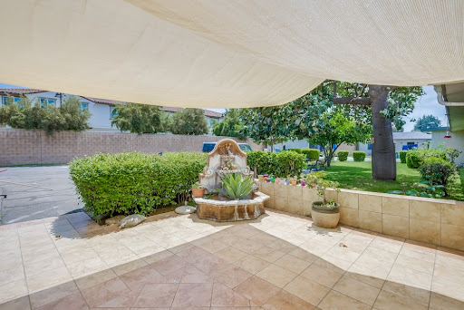 A serene outdoor space featuring a charming fountain surrounded by lush greenery.