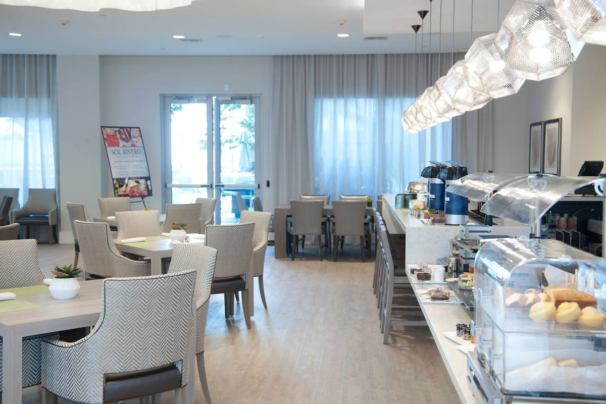 A modern breakfast area with a buffet counter and dining tables.