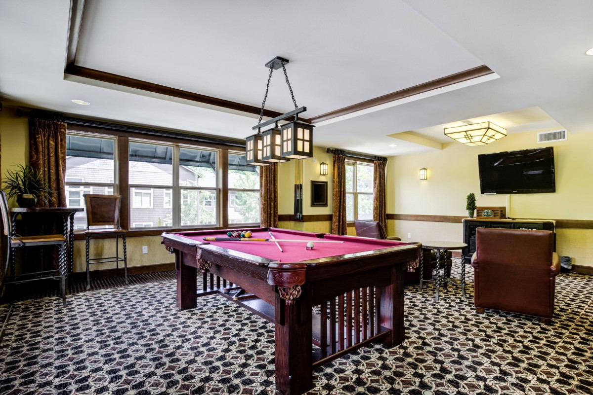 A stylish game room featuring a classic billiards table and elegant decor.