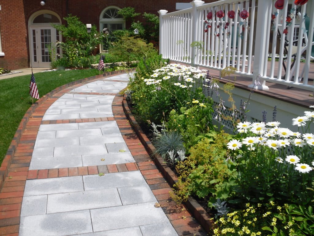 A beautifully landscaped garden path bordered by colorful flowers and greenery.