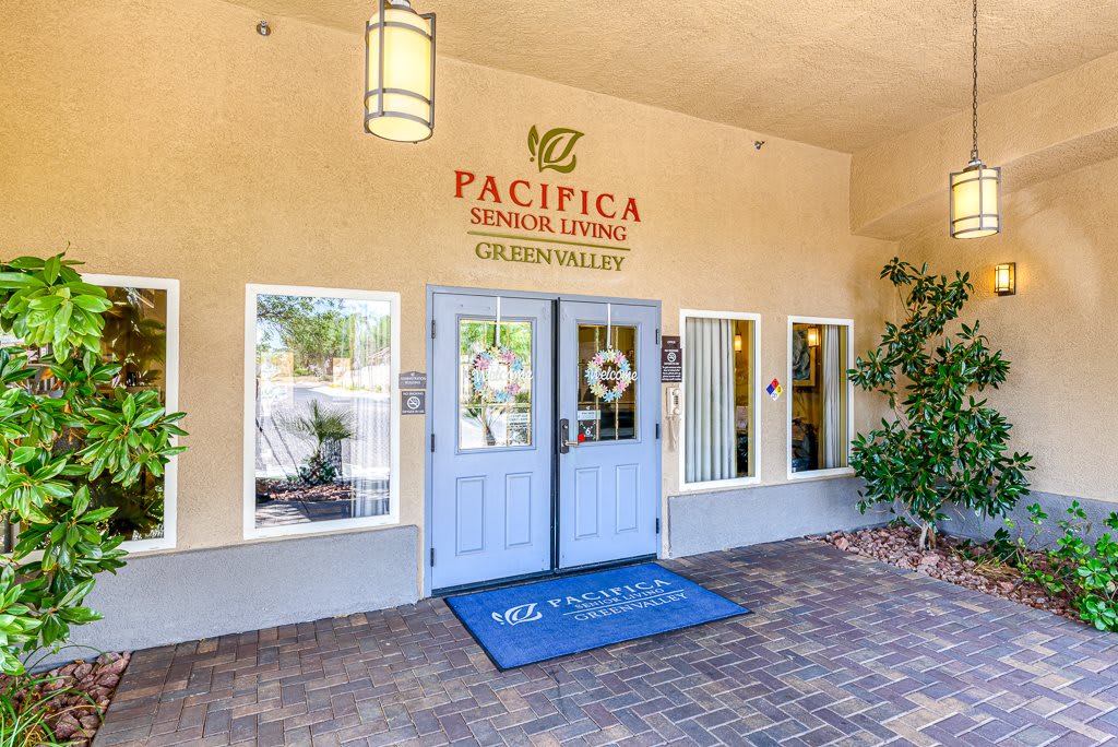 Entrance to a building with blue doors and a business sign above.